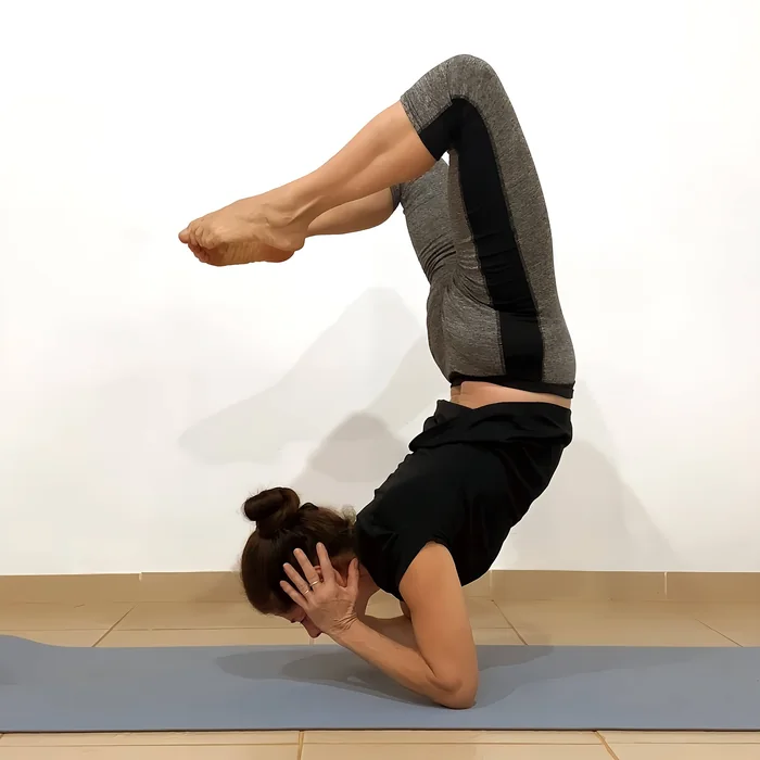 Andrea Piccardo practicando una postura de yoga (parada sobre codos)